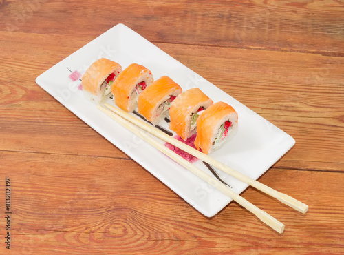Sushi with salmon with chopsticks on rectangular dish
