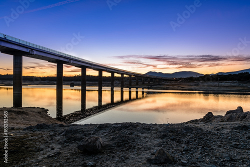 Silhouette Of Bridge Over lage at sunset © jjfarq