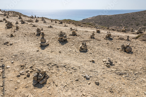 Landscape with small piles of rocks left there by the visitors as a form of a memento. Prasonisi National Park on the southern end of Rhodes in Greece 
