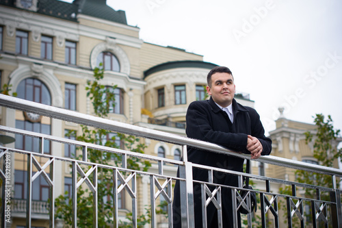 Portrait of an young happy plus size handsome European or American businessman.  businessman wearing suit, rest at city center, planning future project.  © T.Den_Team