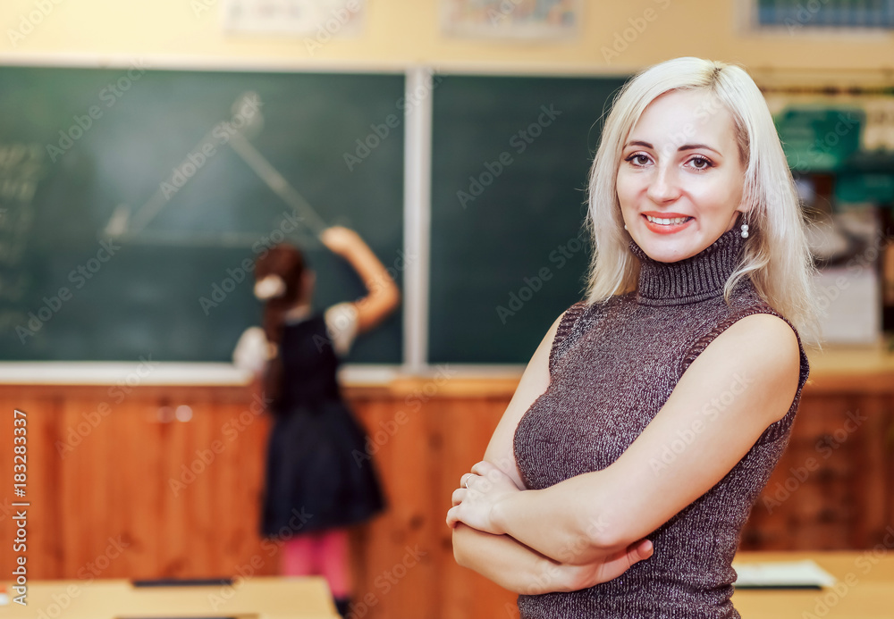 Young teacher girl. Smiling Teacher Teacher smiling standing in class. Young teacher girl. Smiling Teacher Teacher smiling standing in class.