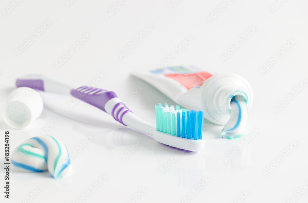 A tube of toothpaste and a toothbrush on white background A tube of toothpaste and a toothbrush on white background