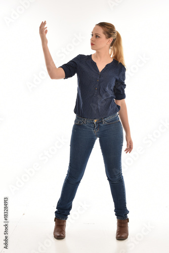 full length portrait of air wearing blue shirt and denim pants, standing pose on white background.