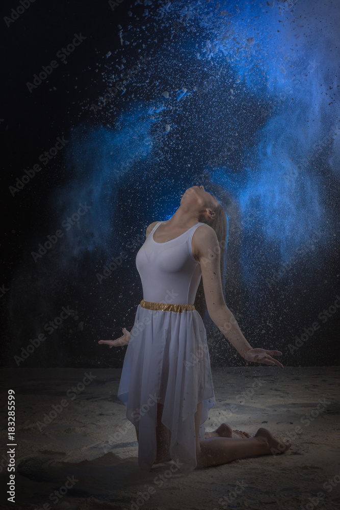 Beautiful slim female dancer in studio during Powder Photo Shoot with colored light