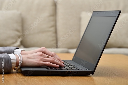Woman working at home office hands on keyboard close up