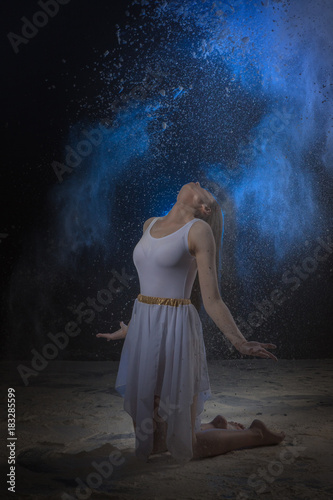 Beautiful slim female dancer in studio during Powder Photo Shoot with colored light