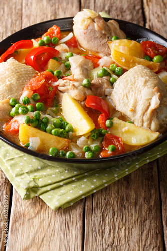 Philippine Afritada: chicken stew with vegetables close-up in a bowl. vertical photo