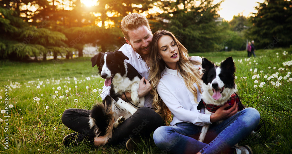 Romantic happy couple in love enjoying their time with pets in nature