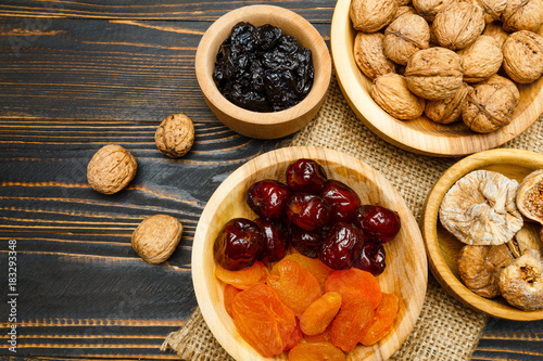 dried fruits figs, apricots, plums and nuts on wooden background