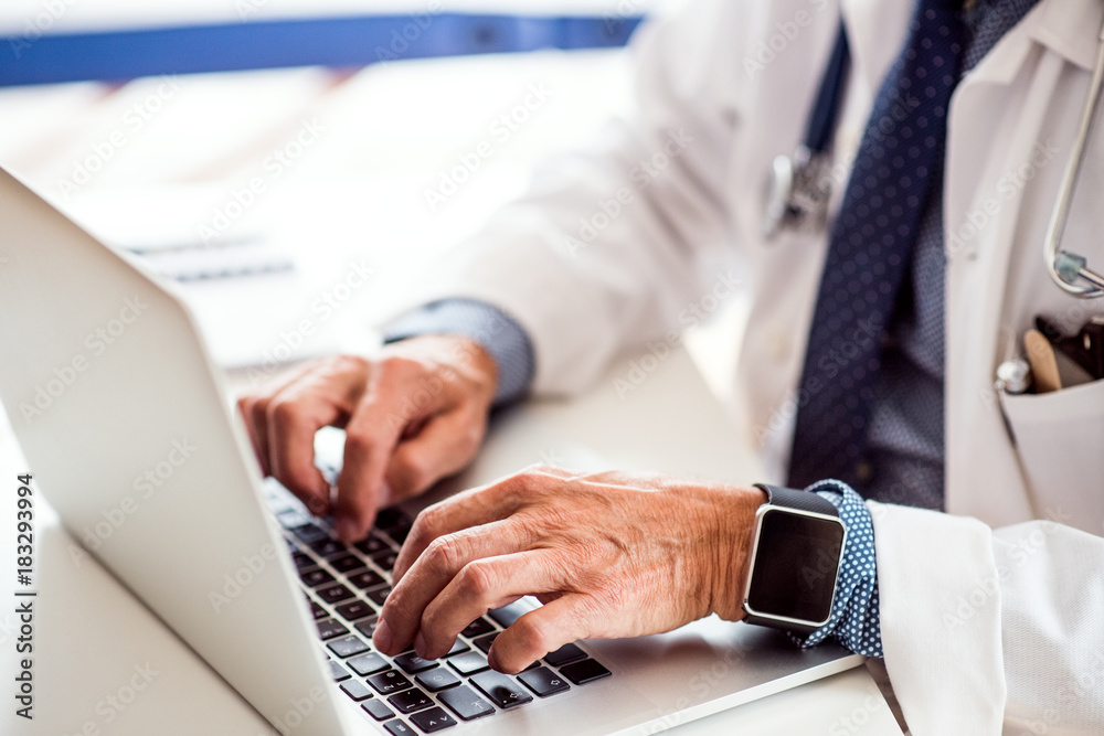 Senior doctor with laptop working at the office desk. Senior doctor with laptop working at the office desk.