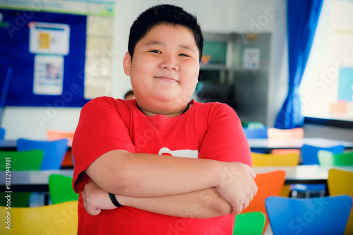 Asian obese boy standing crossed arms and cute smile photo