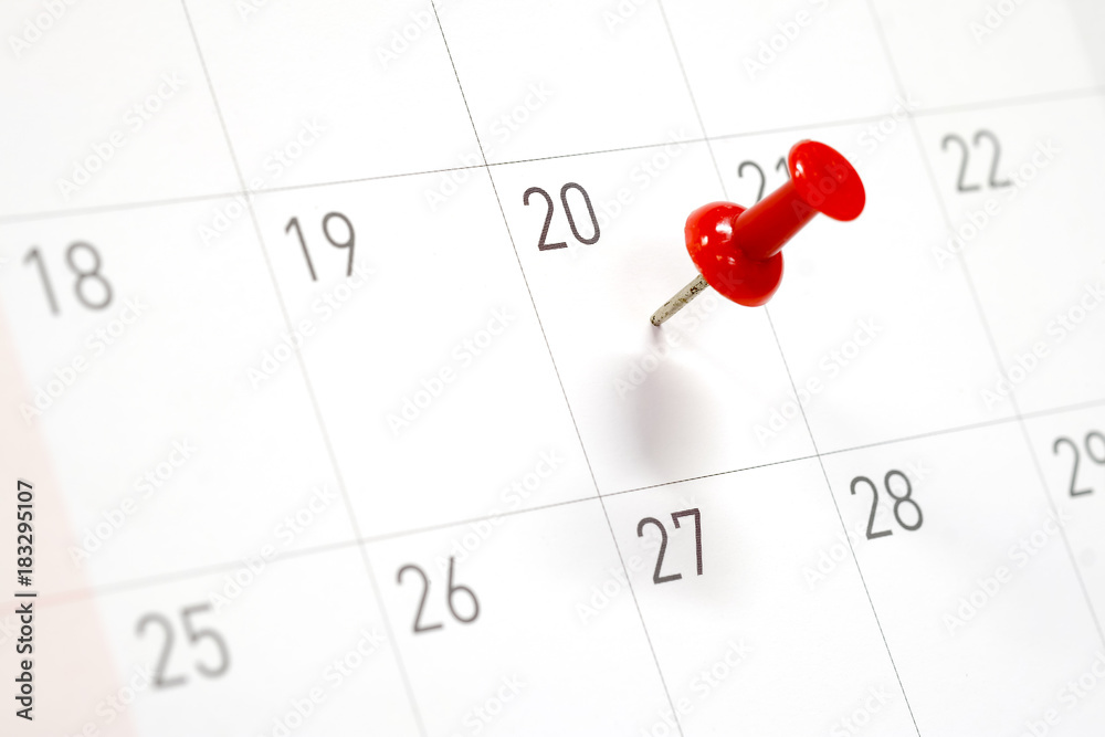 Embroidered red pins on a calendar on the 20th with selective focus