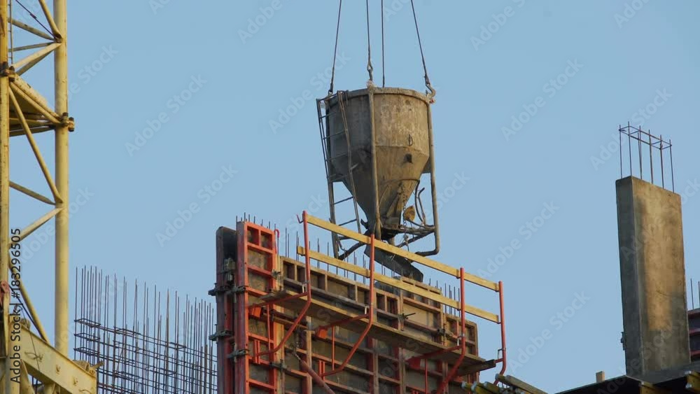 Crane carrying concrete for pouring walls and partitions at housing estate Crane carrying concrete for pouring walls and partitions at housing estate