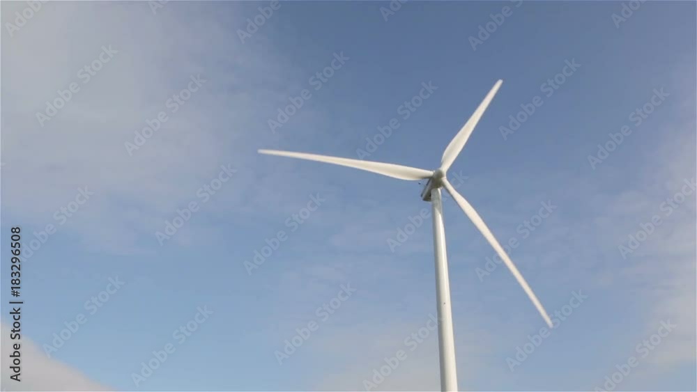 Windmill turning with blue sky in the background Windmill turning with blue sky in the background