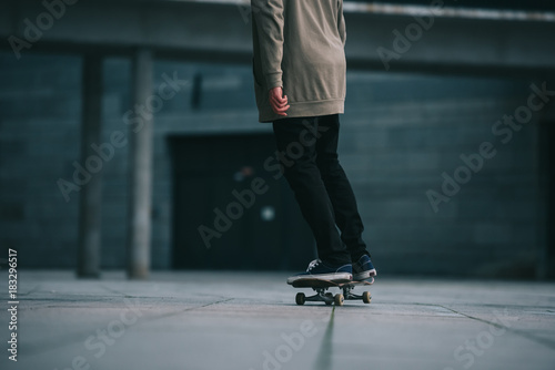 cropped shot of skateboarder riding at urban location