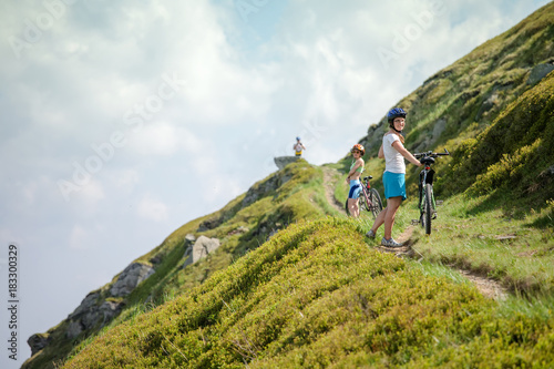 Biker pushes bicycle up in the mountains