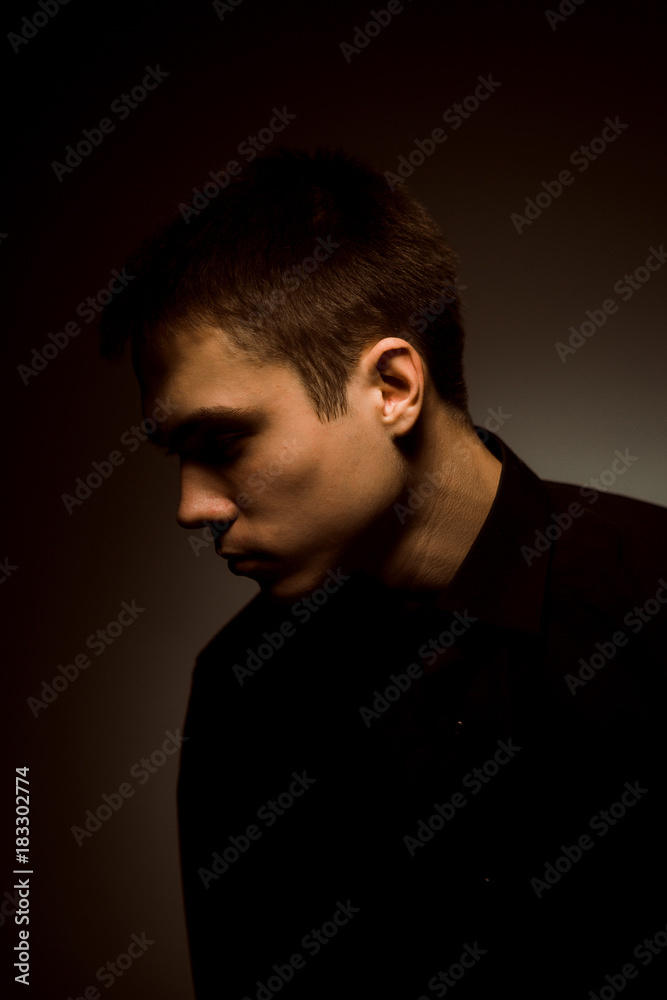 young guy on a dark studio background