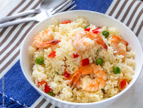 Sticky Fried Rice with Shrimp, Bell Peppers and Green Peas Served in a White Bowl.