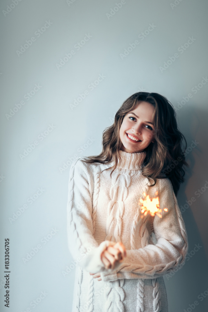 Happy beautiful woman holding festive sparkler Happy beautiful woman holding festive sparkler