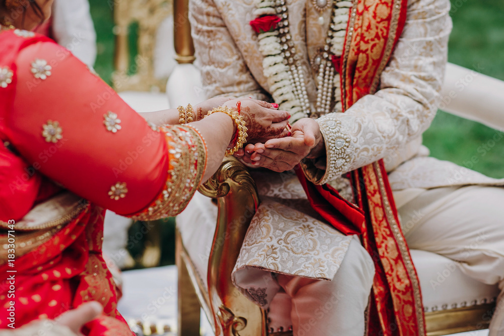Woman gives something to a groom during Hindu wedding ceremony Saptapadi