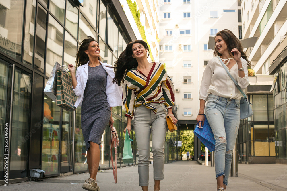 Obraz premium Young women after shopping walking street.
