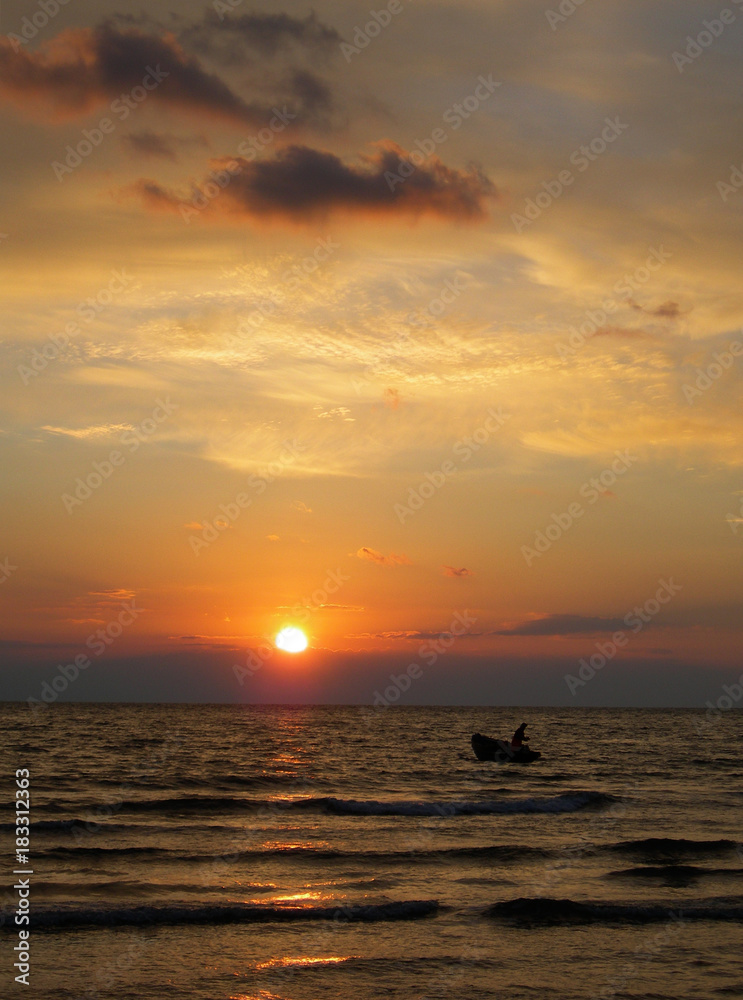 barca sul mare al tramonto,pescatore tra le onde