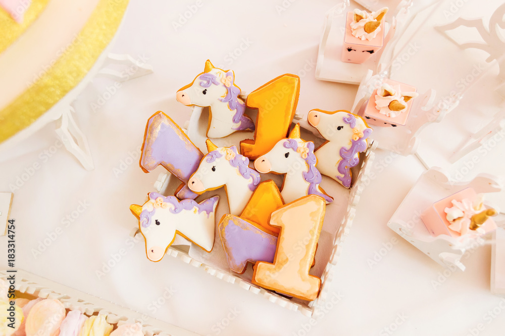 Obraz premium cookies in the form of unicorn and mini cakes on a white tablecl