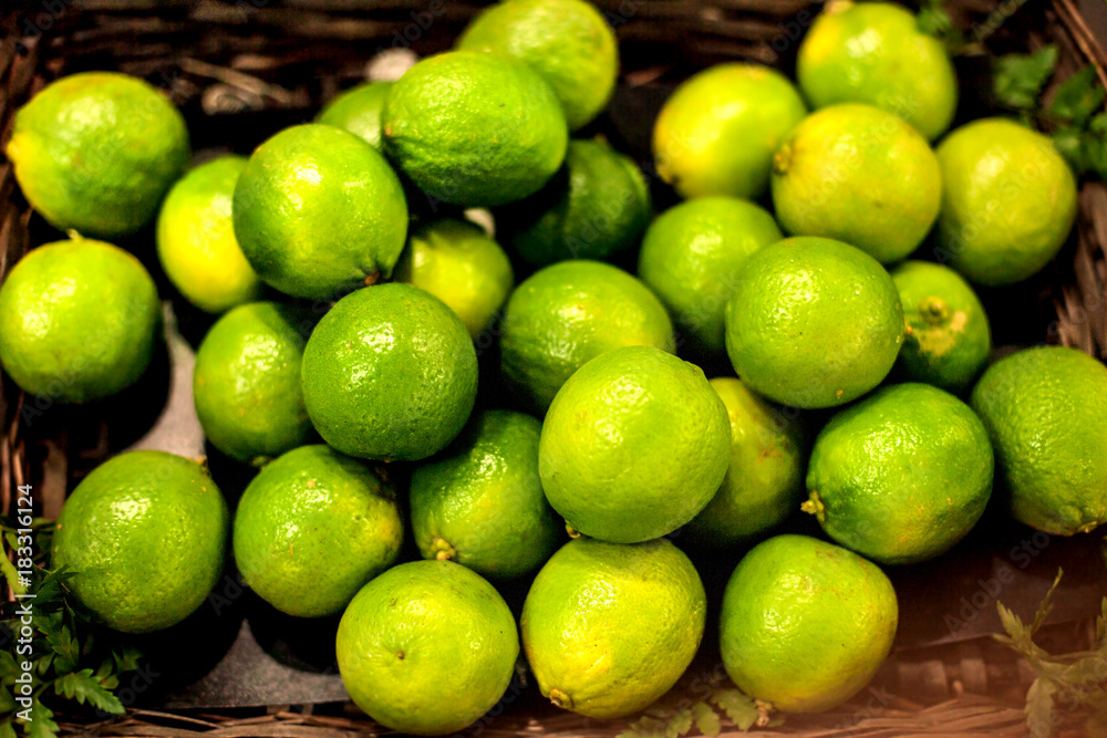 Organic pile of green Limes on a local farmer market. Healthy local food market concept in vintage hipster style. Organic pile of green Limes on a local farmer market. Healthy local food market concept in vintage hipster style.