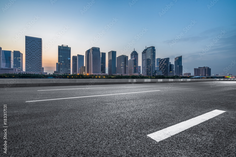 urban traffic road with cityscape in background at dusk, China.