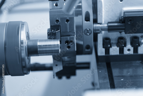 CNC lathe machine (Turning machine) cutting the metal screw thread tube part.Thread machining process.