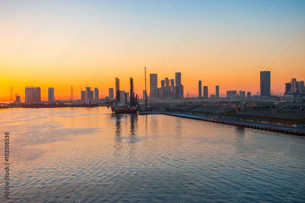 Abu Dhabi port and skyline at sunset.