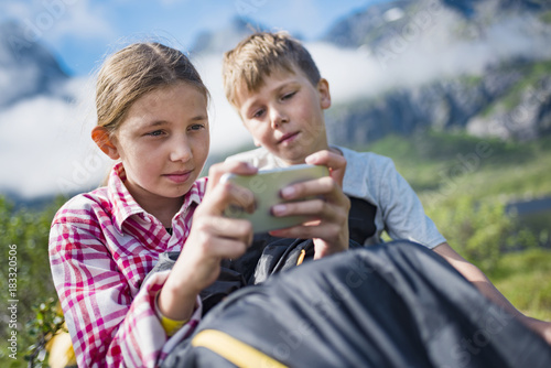 Brother and sister using cell phone