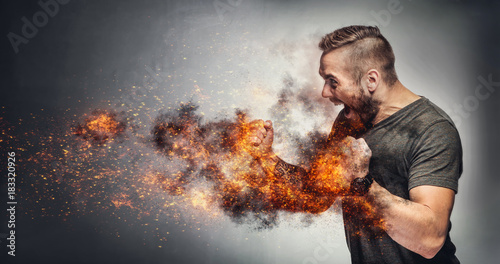 Excited man in fighting gesture with fists on fire. photo