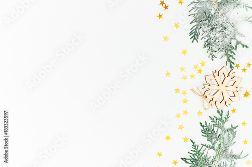 Christmas composition with fir branches, decoration with golden confetti on white background. Flat lay, top view