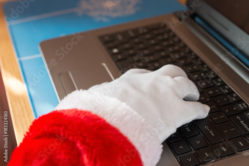 Santa Claus using laptop and typing on the keyboard