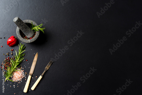 Food background with fresh herbs,  spices and stone mortar