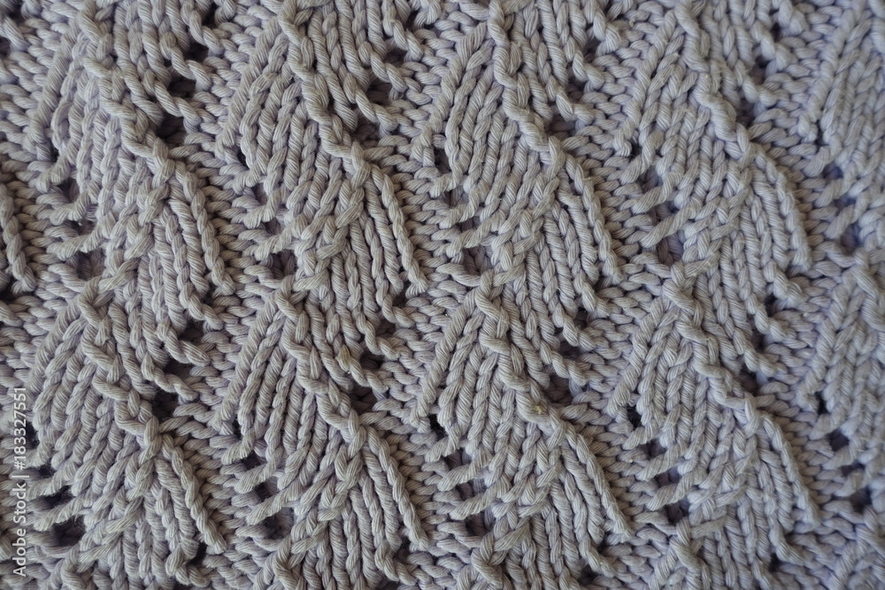Relief pattern with perforations on handmade gray knitwork Relief pattern with perforations on handmade gray knitwork