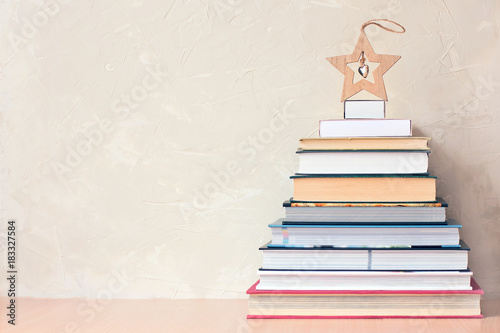Christmas background with a pile of books and a wooden star