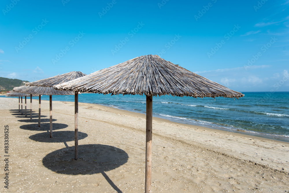 Sarty, Greece, Summer beach without people, sea and sand, empty sea and beach background with straw umbrellas