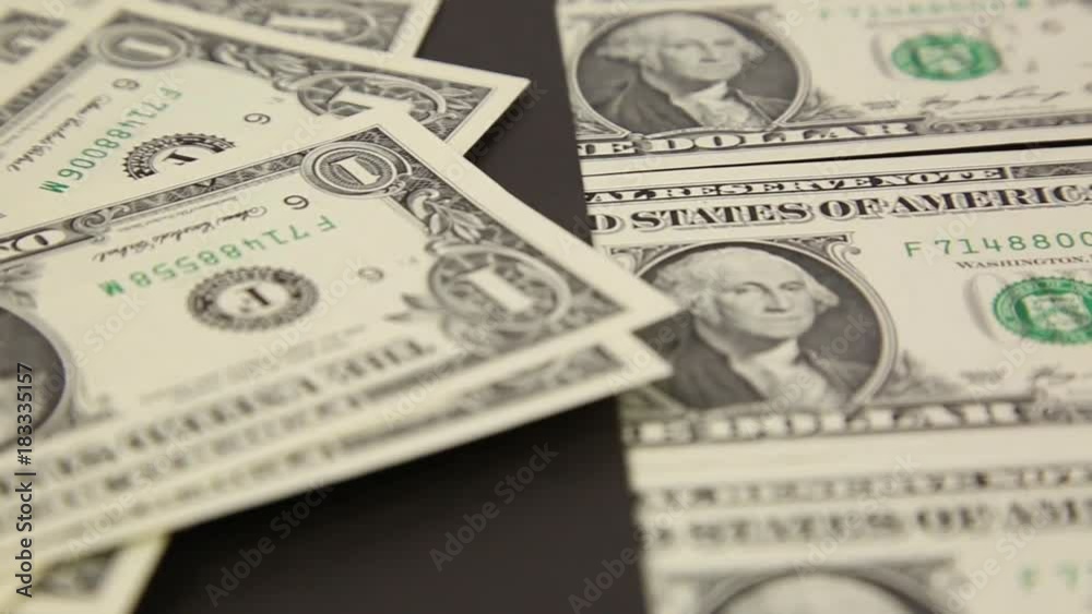 Dollars on a black background. Paper dollars are lined on a black background with a vertical strip. Dollars on a black background. Paper dollars are lined on a black background with a vertical strip.