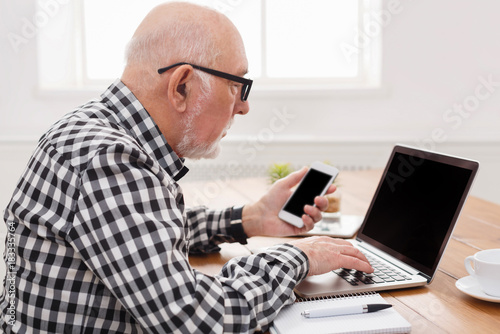 Senior man using laptop and smartphone mockup