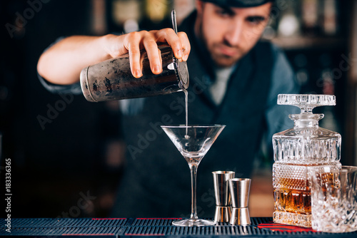 Dry martini close up. Preparation of martini at bar. Portrait of barman