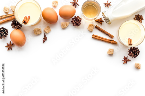 Ingredients for eggnog. Eggs, milk, cinnamon, whiskey on white background top view copyspace