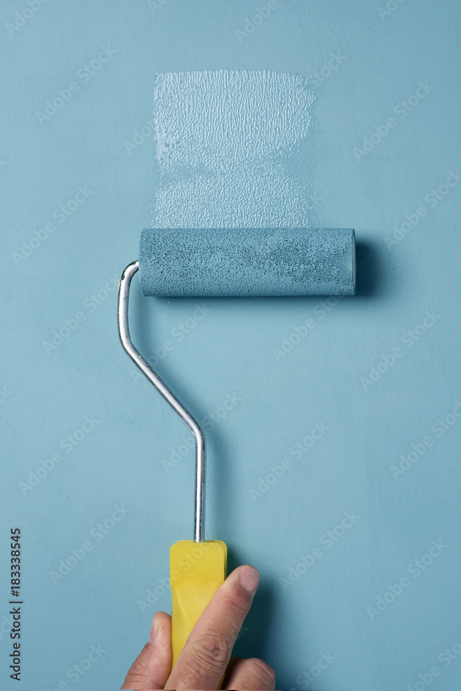 Obraz premium young man painting with a paint roller