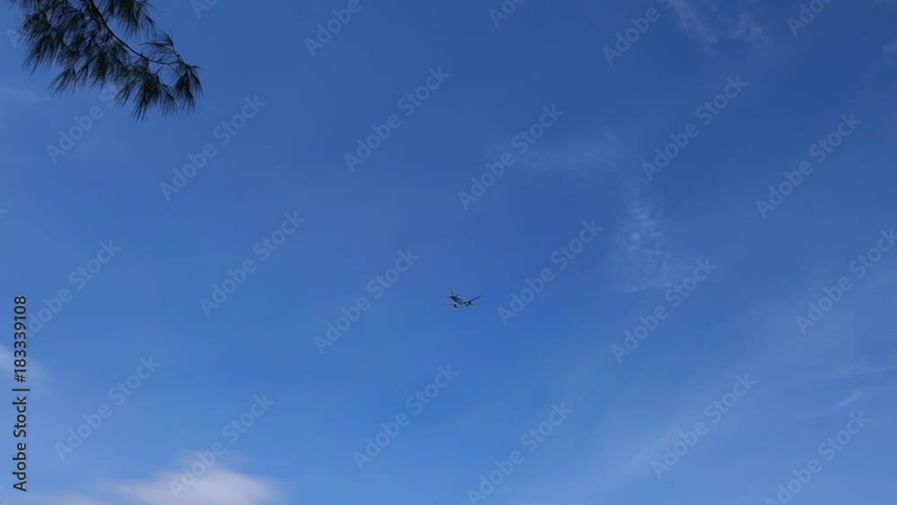 Passenger plane taking off overhead through blue sky Passenger plane taking off overhead through blue sky