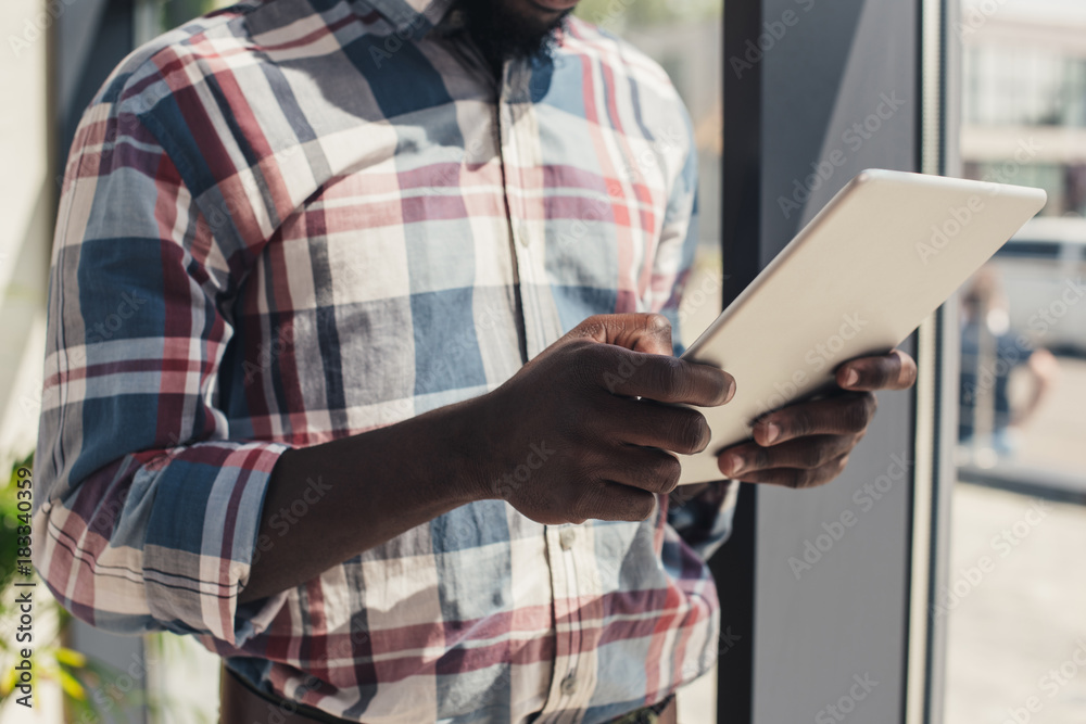 Obraz premium cropped view of african american man using digital tablet