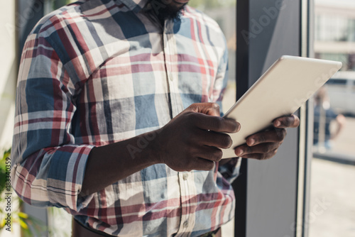 cropped view of african american man using digital tablet
