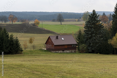 hunting lodge on a meadow near a deep spruce forest on the Czech Highlands