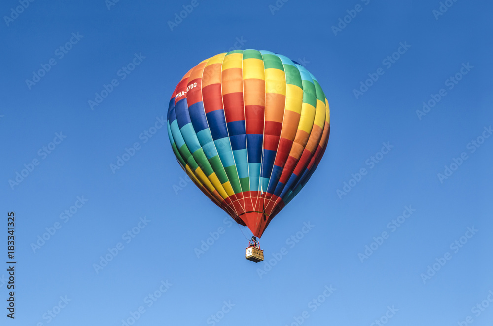Naklejka premium Bright balloon with a mosaic pattern of red, yellow,green and blue colors in the sky over the capital of Armenia, in celebration of