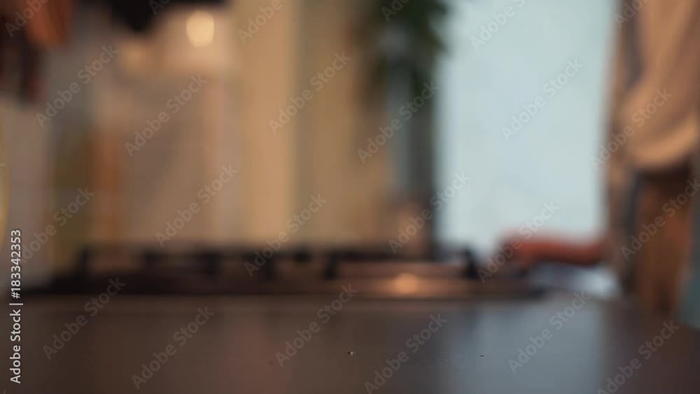 Hand takes water glass from kitchen desk to drink Hand takes water glass from kitchen desk to drink
